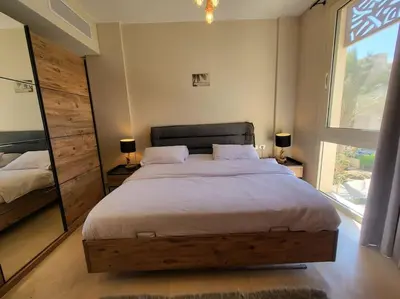 a bedroom with a large bed and a large window at Mangroovy Serinity 2br pool view in Hurghada