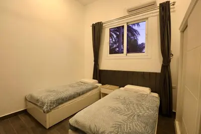 two beds in a small room with a window at Sultan Guest House in Luxor