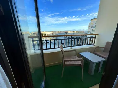 a balcony with two chairs and a table on a building at Aldau Sunset in Hurghada