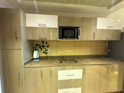 a kitchen with wooden cabinets and a microwave at Aldau Sunset in Hurghada