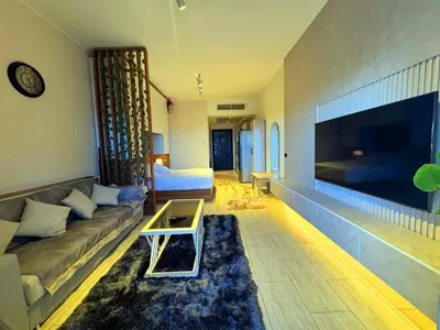 a living room with a couch and a large flat screen tv at Aldau Sunset in Hurghada