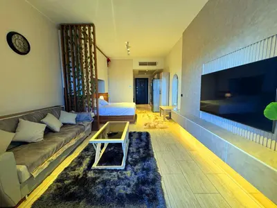 a living room with a couch and a large flat screen tv at Aldau Sunset in Hurghada