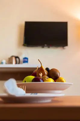 a bowl of fruit on a plate on a table at Al Fanar Azur Hotel in Suwhaj