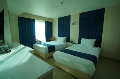 a hotel room with two beds and a television at Al Fanar Azur Hotel in Suwhaj