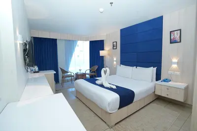 a hotel room with a large bed with a blue wall at Al Fanar Azur Hotel in Suwhaj