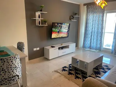 a living room with a flat screen tv on a wall at Red sea-Cozy one bedroom with sea view in Hurghada
