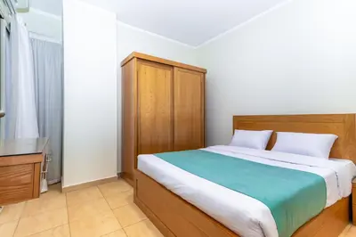 a bedroom with a large bed with a wooden headboard at Delmar Apartments by Peaks in Hurghada