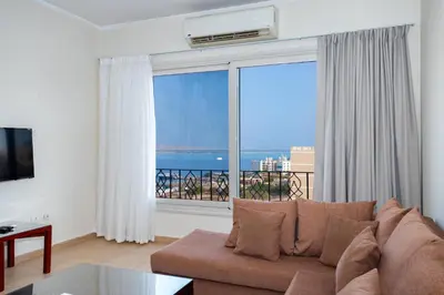 a living room with a couch and a large window at Delmar Apartments by Peaks in Hurghada