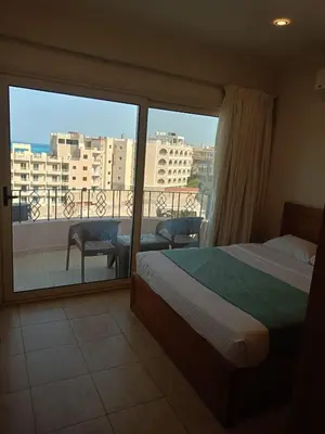 a bedroom with a bed and a balcony with a view at Delmar Apartments by Peaks in Hurghada