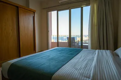 a bedroom with a large bed and a large window at Delmar Apartments by Peaks in Hurghada