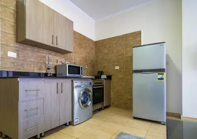 a kitchen with a refrigerator and a washing machine at Delmar Apartments by Peaks in Hurghada
