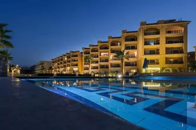 a hotel with a swimming pool at night at Selena bay apartment beach in Hurghada
