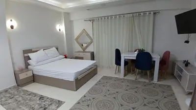 a bedroom with a bed and a desk and a table at Selena bay apartment beach in Hurghada