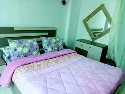 a bedroom with a bed with a pink comforter and a mirror at Selena bay apartment beach in Hurghada