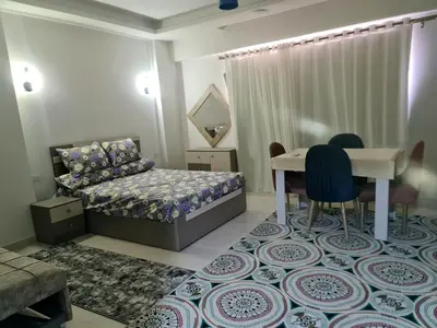 a bedroom with a bed and a table and chairs at Selena bay apartment beach in Hurghada