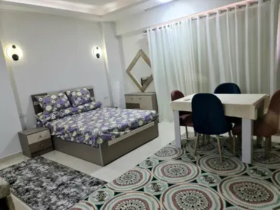 a bedroom with a bed and a table and chairs at Selena bay apartment beach in Hurghada