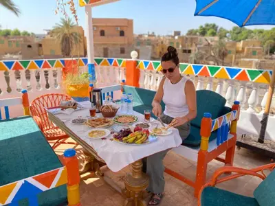 a woman sitting at a table with a plate of food at La Veranda \u967d\u53f0 in Aswan