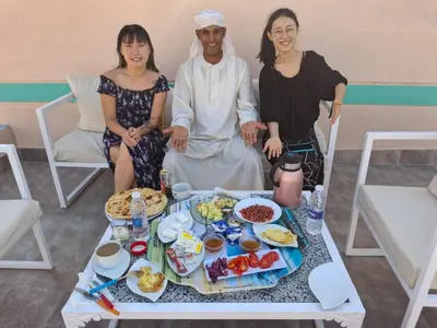 a group of people sitting around a table with food at ATON PALACE Luxor in Luxor