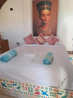 a bed with a painting of a woman on it at ATON PALACE Luxor in Luxor