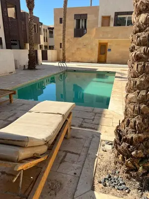 a swimming pool with a bed next to a building at Scarab El Gouna in Hurghada
