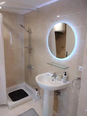 a bathroom with a sink and a shower and a mirror at Hurghada Stylish stay in Hurghada