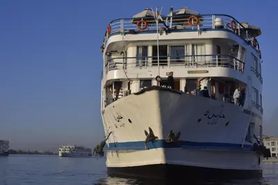 a cruise ship is docked in the water at Hapi V in Aswan