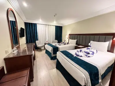 a hotel room with two beds and a desk at Hapi V in Aswan