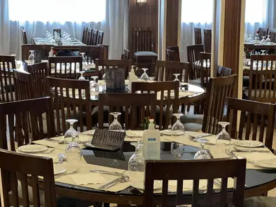a dining room with tables and chairs and a laptop at Hapi V in Aswan