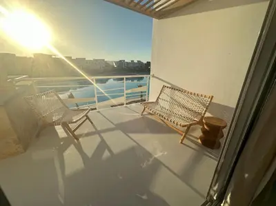 two chairs sitting on a balcony with the sun shining at Penthouse 3 Bedrooms in Swan Lake ElGouna in Hurghada