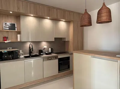 a kitchen with white cabinets and two pendant lights at Penthouse 3 Bedrooms in Swan Lake ElGouna in Hurghada