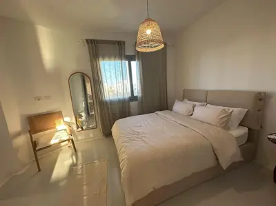 a bedroom with a bed and a mirror and a lamp at Penthouse 3 Bedrooms in Swan Lake ElGouna in Hurghada