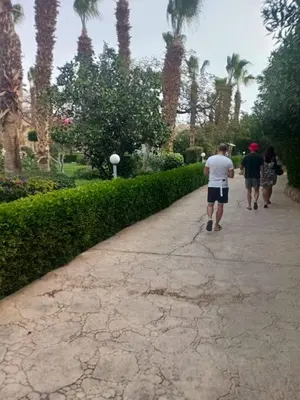 a group of people walking down a sidewalk at شاليه في منتجع ميراج in Hurghada