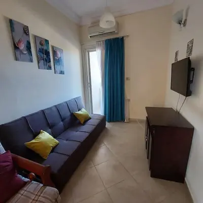 a living room with a couch and a television at Mamsha view 1 bedroom flat beside Russian consulate in Hurghada