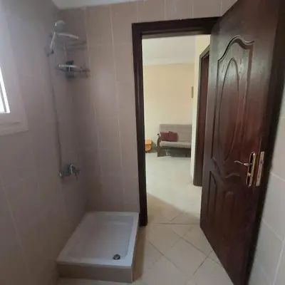 a bathroom with a toilet and a wooden door at Mamsha view 1 bedroom flat beside Russian consulate in Hurghada
