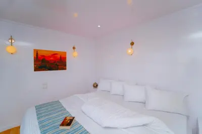 a white bedroom with a white bed with white pillows at Turquoise Dahabiya , 3,4,7 nights sailing between Luxor and Aswan in Luxor