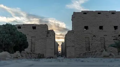 an old stone building with a sunset in the background at Turquoise Dahabiya , 3,4,7 nights sailing between Luxor and Aswan in Luxor