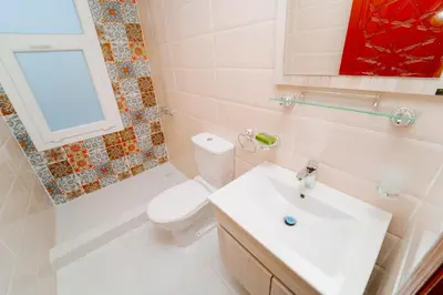 a white bathroom with a toilet and a sink at Turquoise Dahabiya , 3,4,7 nights sailing between Luxor and Aswan in Luxor