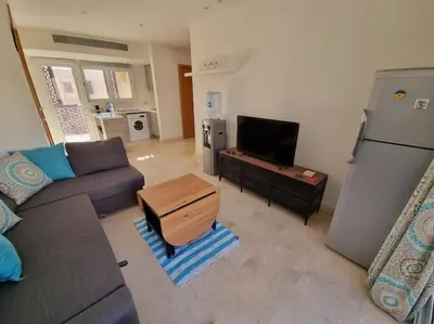 a living room with a couch and a refrigerator at EL GOUNA Scarab Club One bedroom in Hurghada