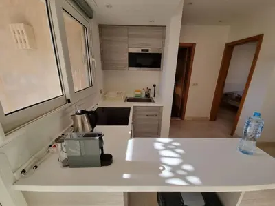 a kitchen with a white counter top with a bottle of water at EL GOUNA Scarab Club One bedroom in Hurghada