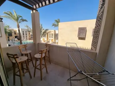 a balcony with chairs and tables on a balcony at EL GOUNA Scarab Club One bedroom in Hurghada