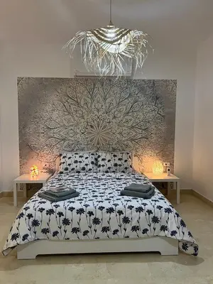 a bedroom with a bed with a floral patterned wall at Villa du bonheur 202 in Hurghada