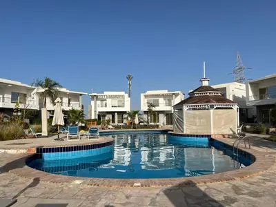 a swimming pool with a gazebo in front of some buildings at Villa du bonheur 202 in Hurghada