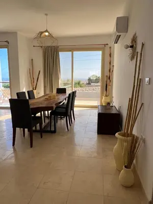 a dining room with a table and chairs and a large window at Villa du bonheur 202 in Hurghada