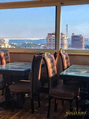 a restaurant with tables and chairs and a large window at Salvatore Rooms- All Inclusive in Hurghada