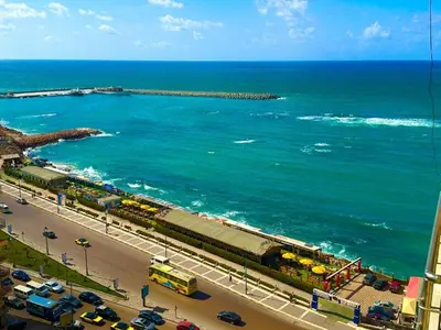 a view of the ocean and a beach with cars at Salvatore Rooms- All Inclusive in Hurghada