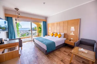 a bedroom with a bed and a couch and a window at Salvatore Rooms-All Inclusive Makadi in Hurghada