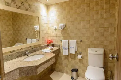 a bathroom with a toilet and a sink and a mirror at Salvatore Rooms-All Inclusive Makadi in Hurghada