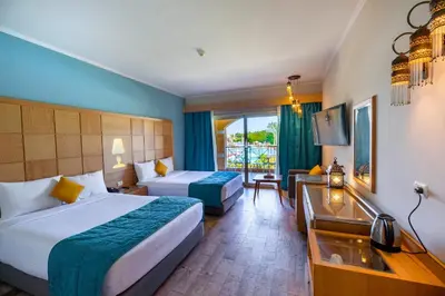 a hotel room with two beds and a television at Salvatore Rooms-All Inclusive Makadi in Hurghada