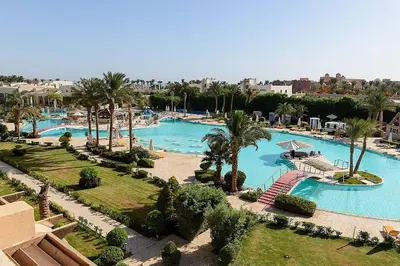 an overhead view of a large swimming pool with palm trees at Salvatore Rooms-All Inclusive Makadi in Hurghada
