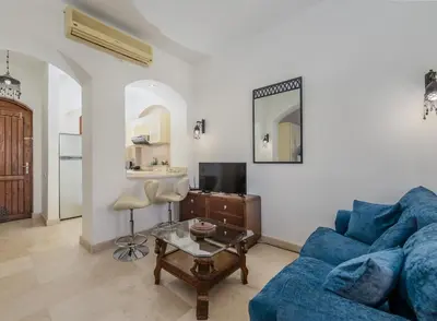 a living room with a blue couch and a table at Cozy Studio Ground floor in Upper Nubia in Hurghada